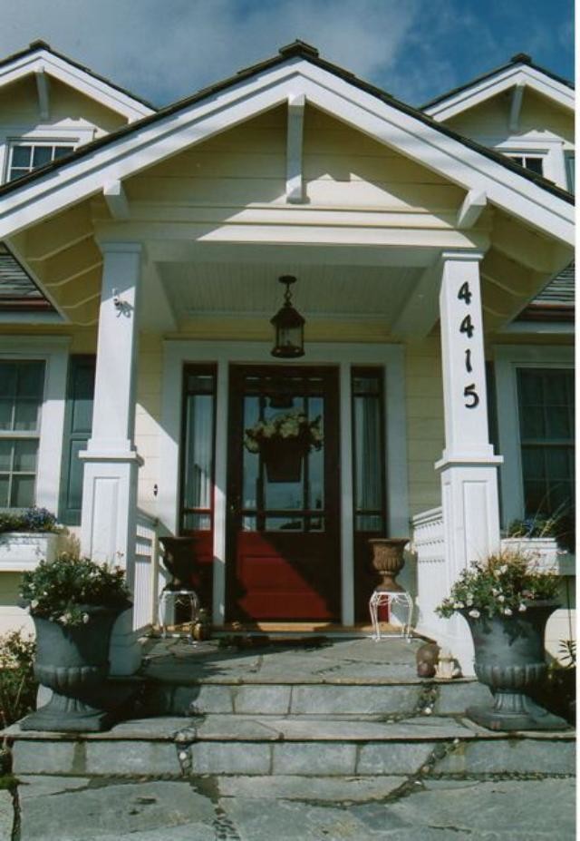 Exempel på en liten klassisk ingång och ytterdörr, med gula väggar, skiffergolv, en enkeldörr och en röd dörr