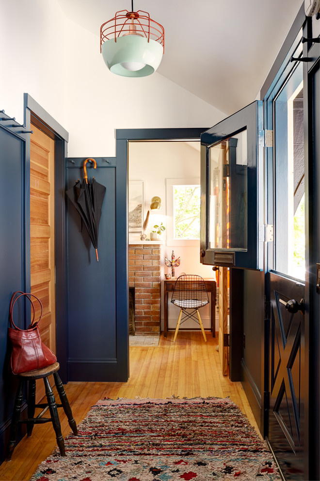 Idéer för eklektiska entréer, med blå väggar, mellanmörkt trägolv, en tvådelad stalldörr och en blå dörr