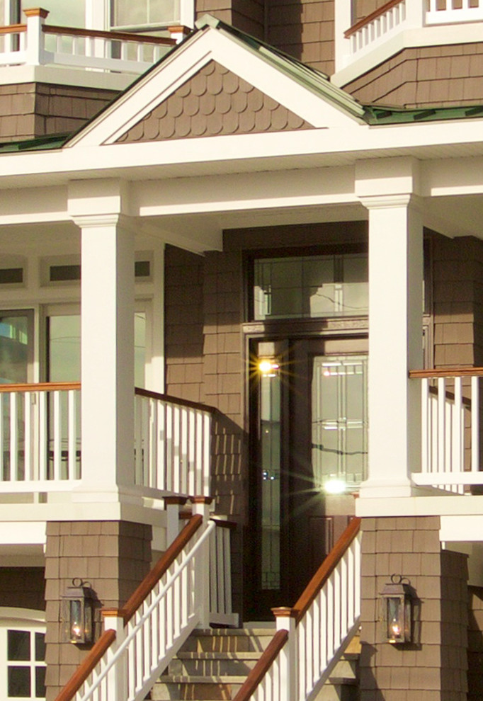 This is an example of a large nautical entrance in New York with brown walls, limestone flooring, a single front door and a glass front door.