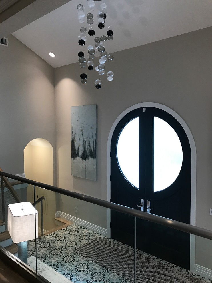 This is an example of a medium sized beach style foyer in Tampa with grey walls, porcelain flooring, a double front door and a black front door.