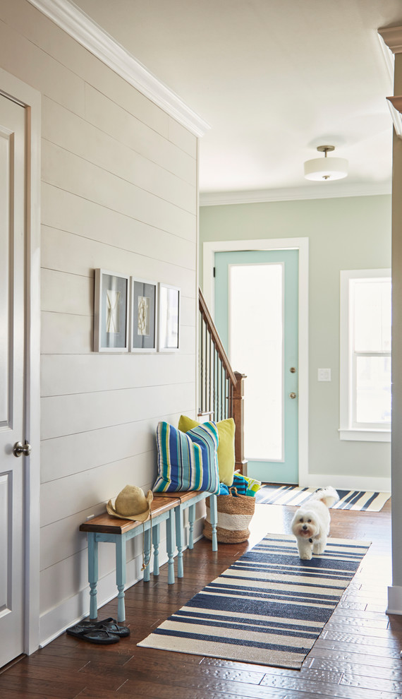 Idee per un corridoio stile marinaro con parquet scuro, una porta singola, una porta blu, pavimento marrone e pareti beige