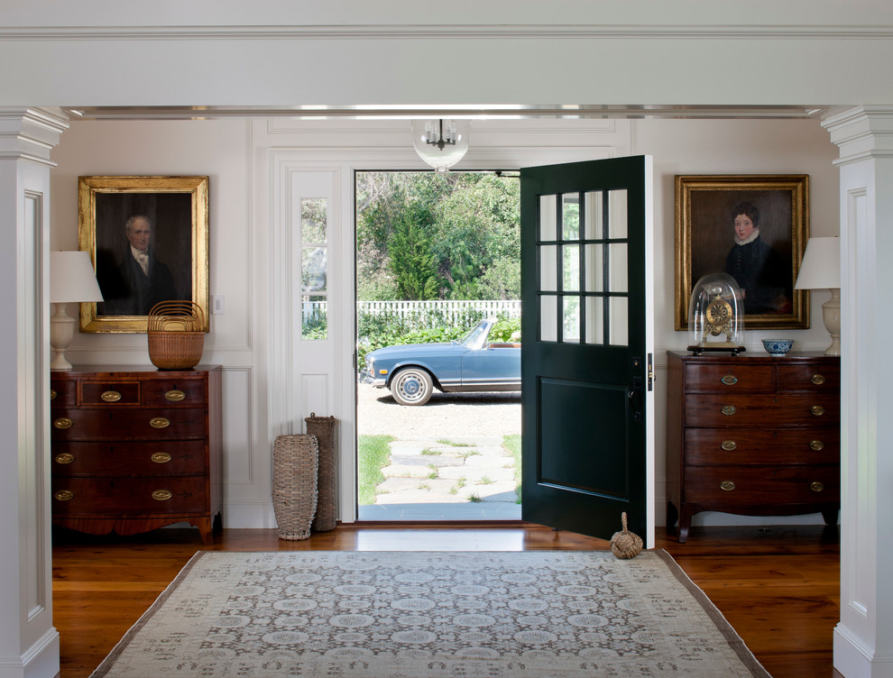 This is an example of a beach style front door in Boston with white walls, a single front door, a green front door and feature lighting.