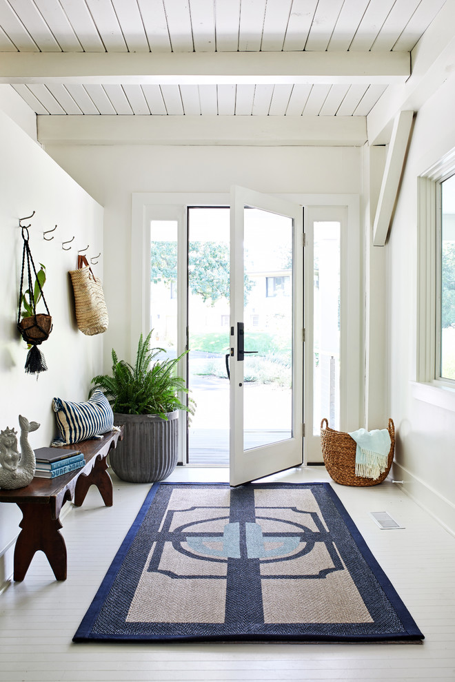 Imagen de distribuidor marinero con paredes blancas, suelo de madera pintada, puerta simple, puerta de vidrio y suelo blanco