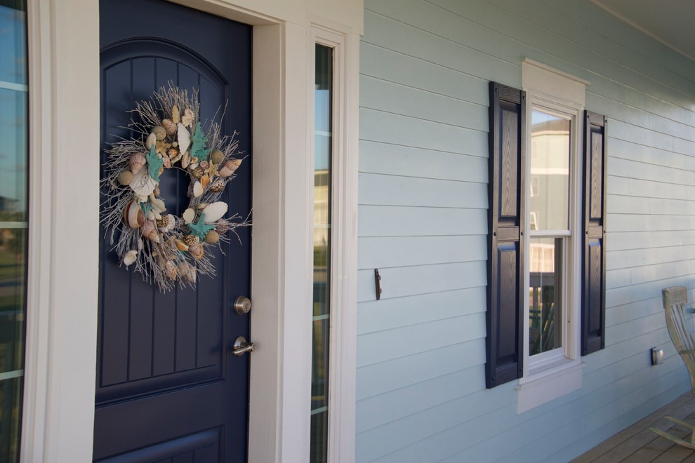 ヒューストンにある高級な中くらいなビーチスタイルのおしゃれな玄関ドア (青い壁、無垢フローリング、青いドア) の写真