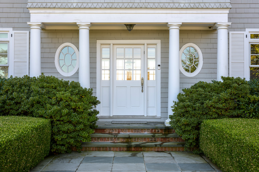 На фото: входная дверь в морском стиле с одностворчатой входной дверью и белой входной дверью с