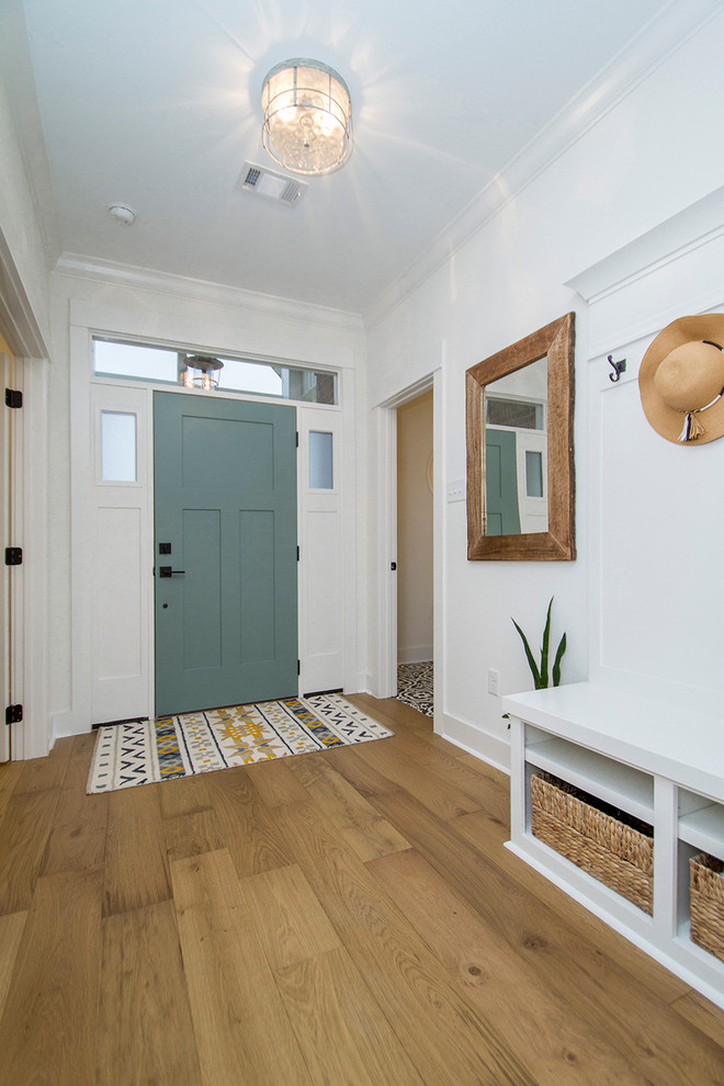Imagen de hall costero con paredes blancas, suelo de madera clara, puerta simple, puerta verde y suelo beige