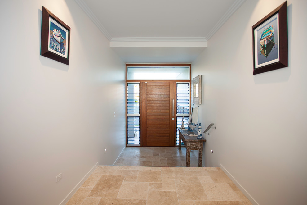 Imagen de distribuidor costero de tamaño medio con paredes blancas, suelo de travertino, puerta simple, puerta de madera clara y suelo beige