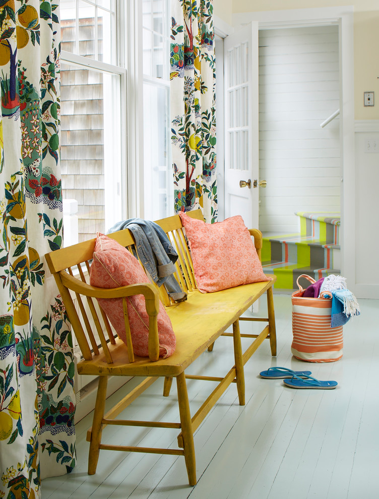 Photo of a beach style hallway in Portland Maine with yellow walls, painted wood flooring, a white front door and grey floors.