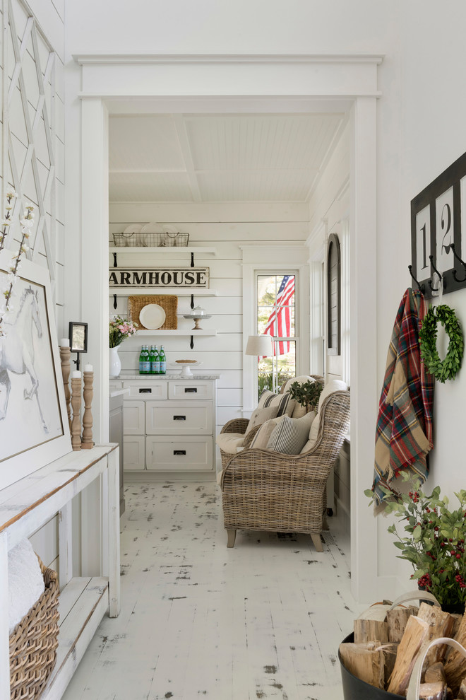 На фото: входная дверь в стиле кантри с белыми стенами, деревянным полом и белым полом с