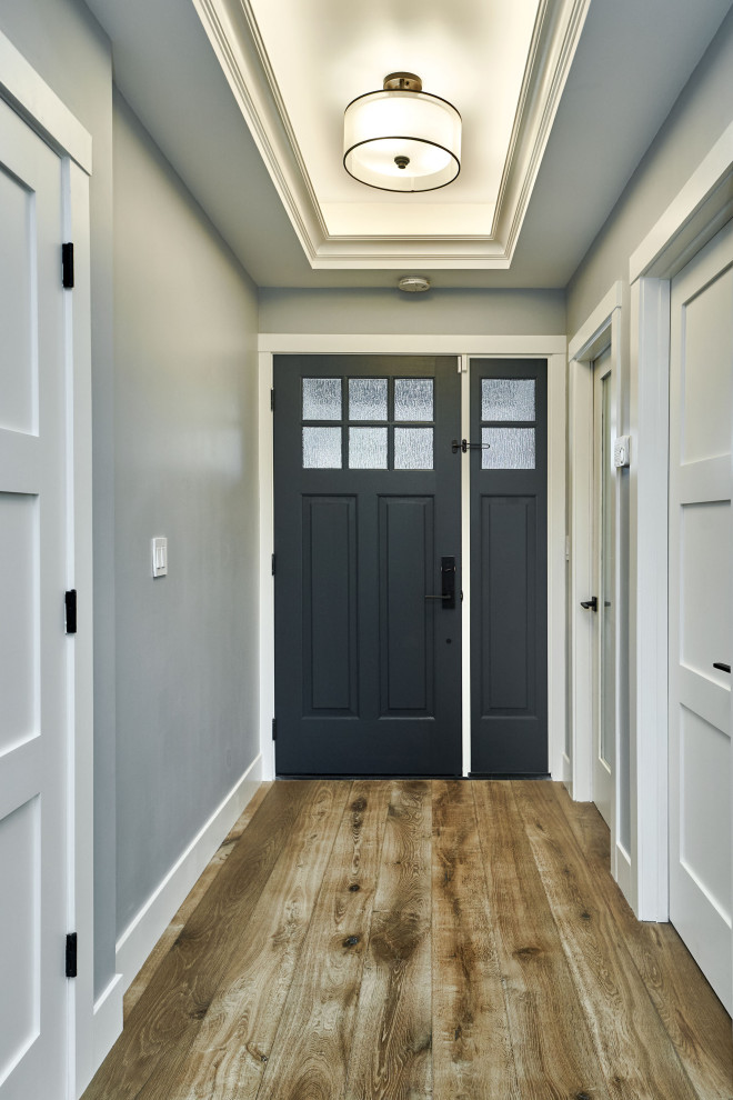 Esempio di una piccola porta d'ingresso minimal con pareti grigie, pavimento in legno massello medio, una porta singola, una porta blu e pavimento multicolore