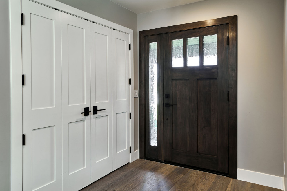 Idée de décoration pour une porte d'entrée minimaliste de taille moyenne avec un mur gris, un sol en bois brun, une porte simple, une porte en bois foncé et un sol marron.