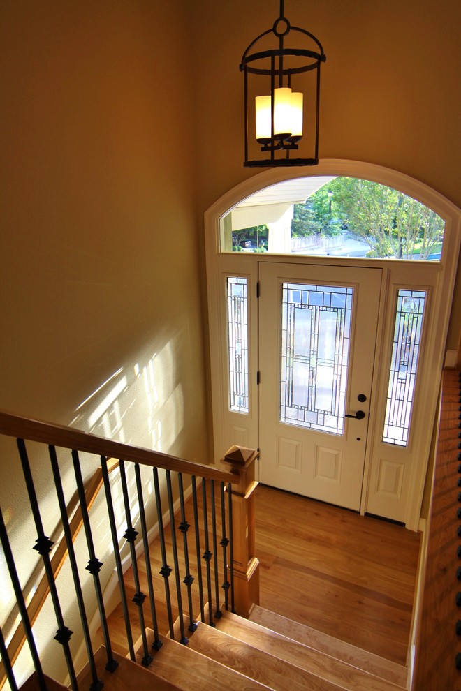 На фото: большое фойе в классическом стиле с бежевыми стенами, паркетным полом среднего тона, одностворчатой входной дверью и белой входной дверью с