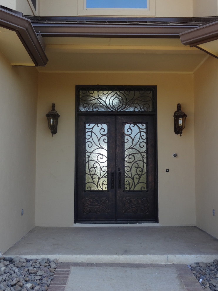 Modelo de puerta principal extra grande con paredes beige, suelo de cemento, puerta doble y puerta metalizada