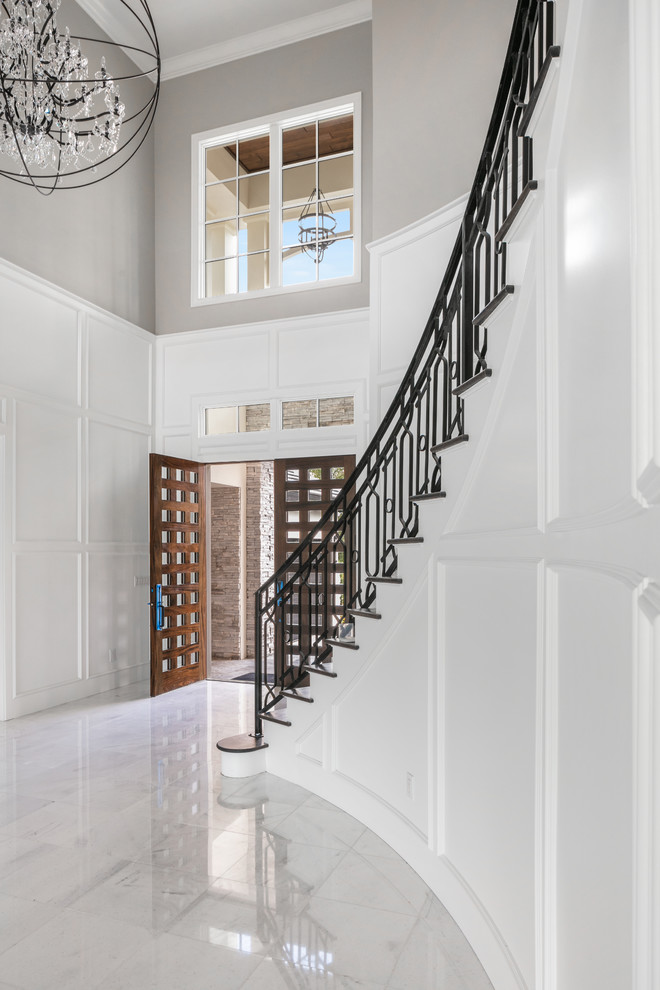 Idée de décoration pour un grand hall d'entrée tradition avec un mur blanc, un sol en carrelage de porcelaine, une porte double, une porte en bois foncé et un sol blanc.