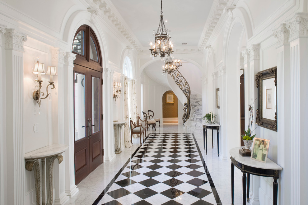 Inspiration pour un grand hall d'entrée traditionnel avec un mur blanc, une porte double, une porte en bois foncé, un sol en marbre et un sol multicolore.