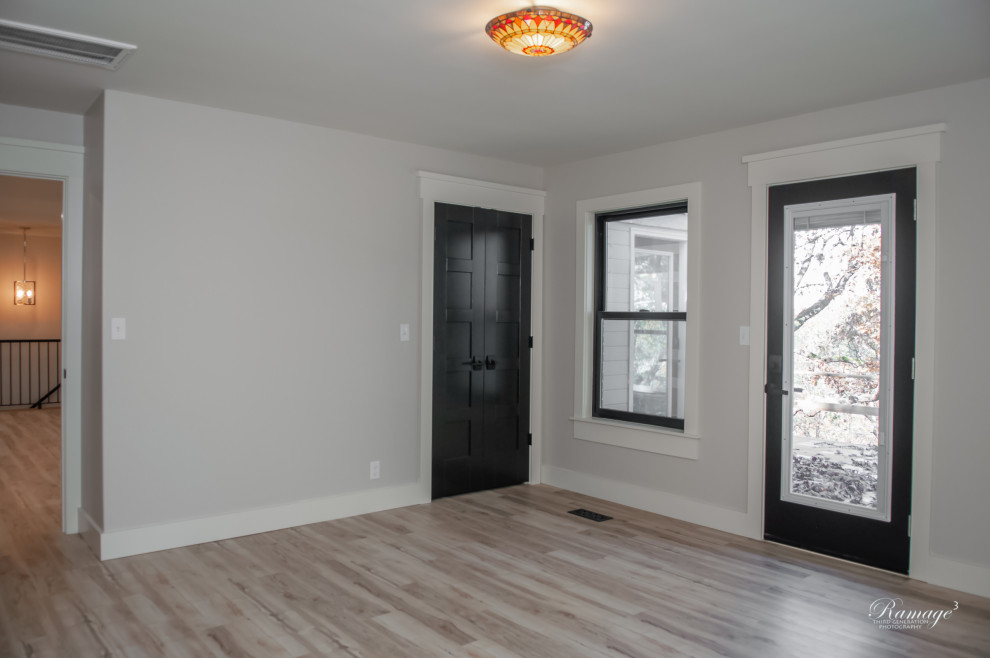 Große Klassische Haustür mit grauer Wandfarbe, Vinylboden, Einzeltür, schwarzer Haustür und beigem Boden in Sonstige