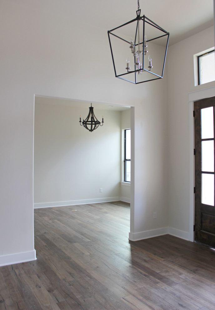 Immagine di un grande ingresso o corridoio country con pareti bianche, pavimento in legno massello medio, una porta a due ante, una porta in legno bruno e pavimento marrone