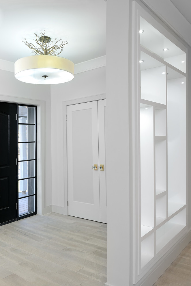 Imagen de distribuidor clásico renovado de tamaño medio con paredes blancas, suelo de madera clara, puerta simple, puerta negra y suelo gris