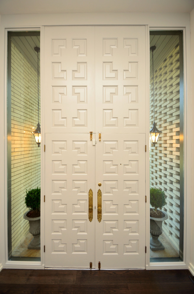 На фото: входная дверь среднего размера в стиле неоклассика (современная классика) с белыми стенами, темным паркетным полом, двустворчатой входной дверью и белой входной дверью