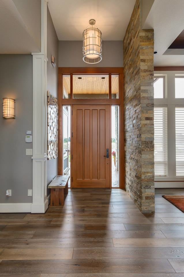 Idee per un ampio ingresso contemporaneo con pareti grigie, pavimento in legno massello medio, una porta singola e una porta in legno bruno