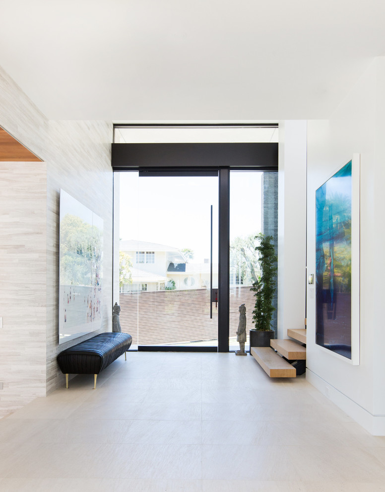 Mid-sized trendy limestone floor entryway photo in Los Angeles with gray walls and a glass front door