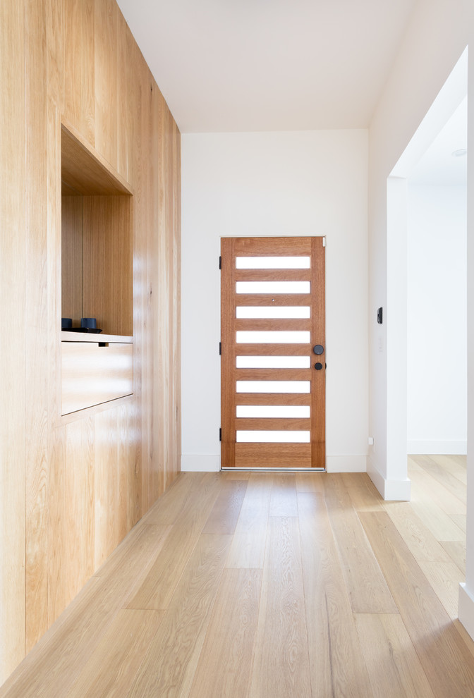 Idee per un ingresso o corridoio moderno con pareti bianche, parquet chiaro, una porta singola e una porta in legno bruno