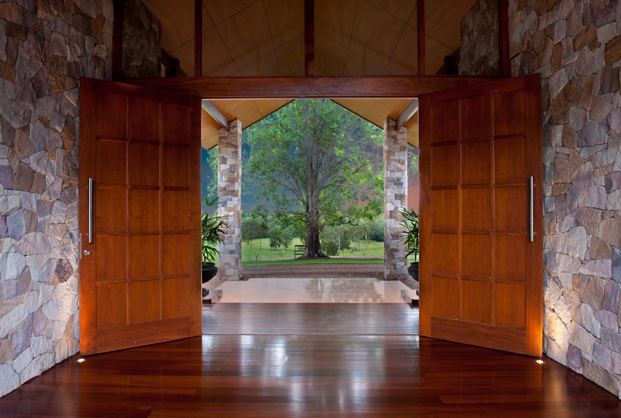 Geräumiges Foyer mit weißer Wandfarbe, dunklem Holzboden und dunkler Holzhaustür in Sunshine Coast