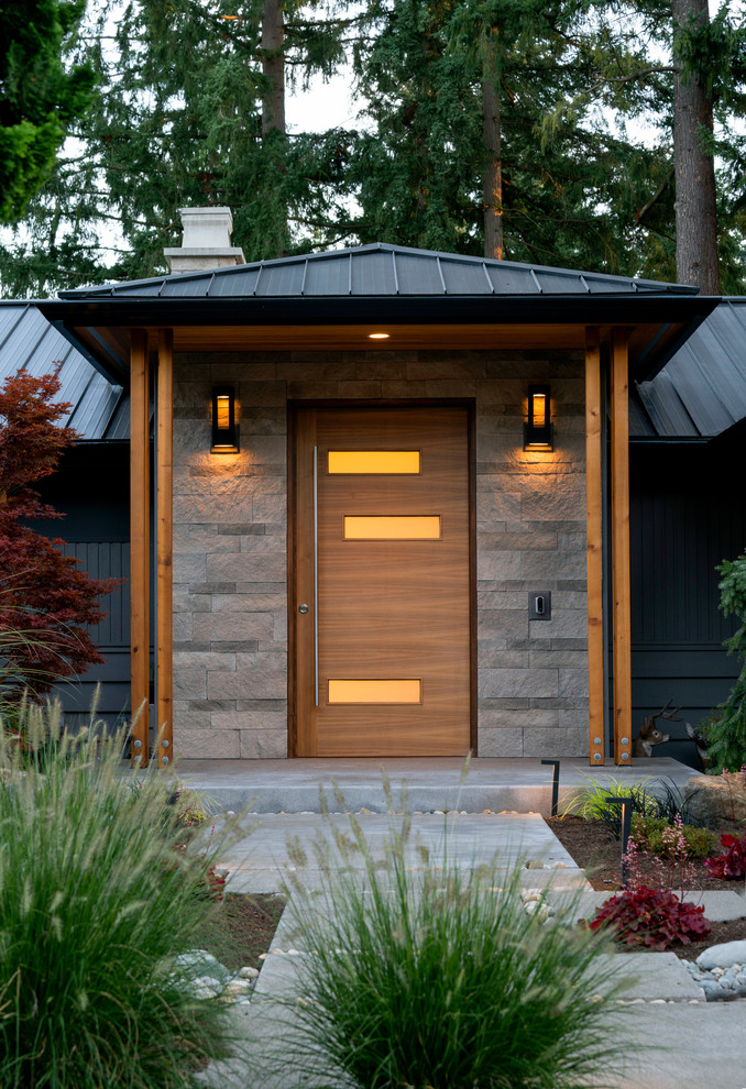 Immagine di una porta d'ingresso minimalista con una porta a pivot e una porta in legno bruno
