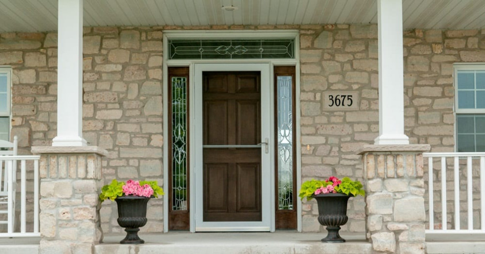 Esempio di una porta d'ingresso tradizionale con pareti beige, pavimento in cemento, una porta singola, una porta in legno scuro e pavimento grigio