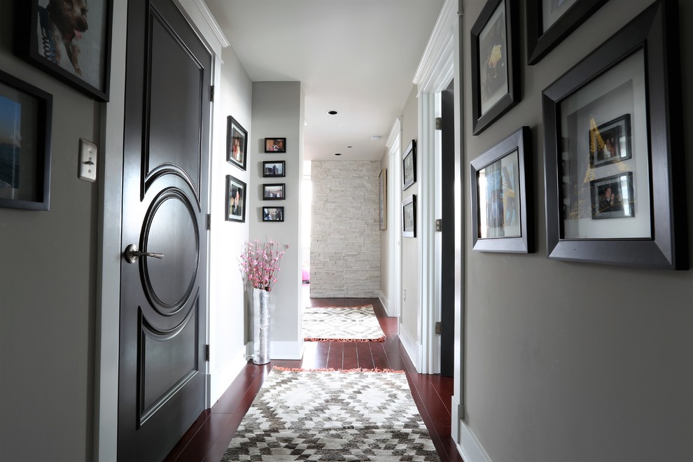 Ispirazione per un piccolo ingresso classico con pareti grigie, parquet scuro, una porta singola, una porta nera e pavimento marrone