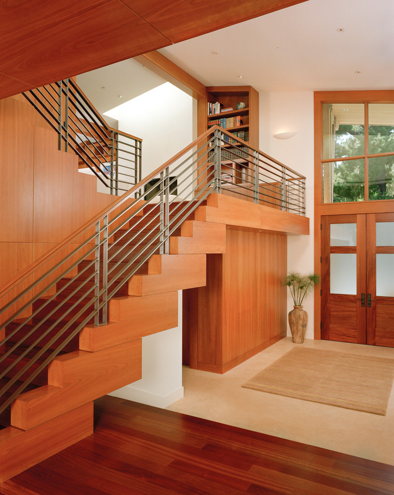 Exemple d'une grande entrée tendance avec un sol en bois brun, un couloir, un mur beige, une porte double et une porte en bois brun.