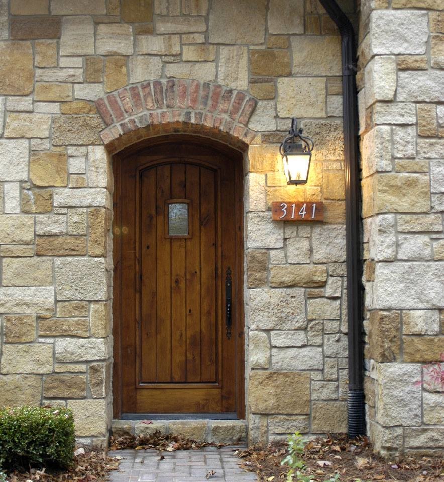 Réalisation d'une porte d'entrée chalet avec un mur beige, une porte simple et une porte en bois brun.