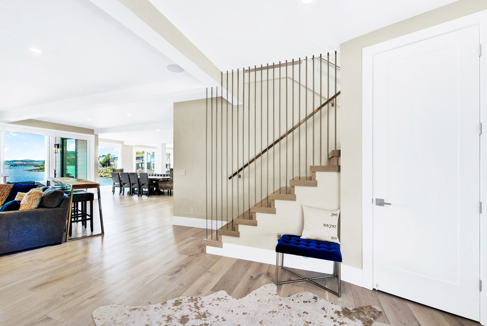 This is an example of a large contemporary foyer in San Francisco with beige walls, light hardwood flooring, a single front door, a glass front door and beige floors.