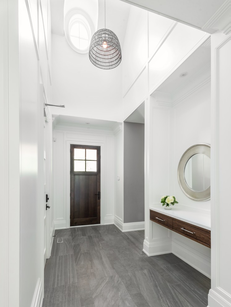 Foto på ett mellanstort funkis kapprum, med vita väggar, klinkergolv i porslin, en enkeldörr, mörk trädörr och grått golv