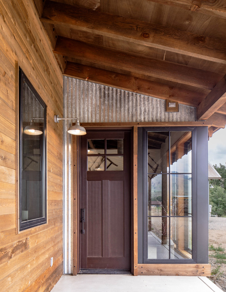 На фото: фойе среднего размера в стиле лофт с бетонным полом, одностворчатой входной дверью, черной входной дверью и серым полом