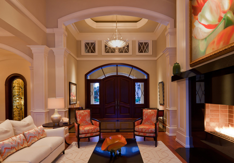 This is an example of a large traditional foyer in Miami with a double front door, beige walls, medium hardwood flooring, a dark wood front door and feature lighting.