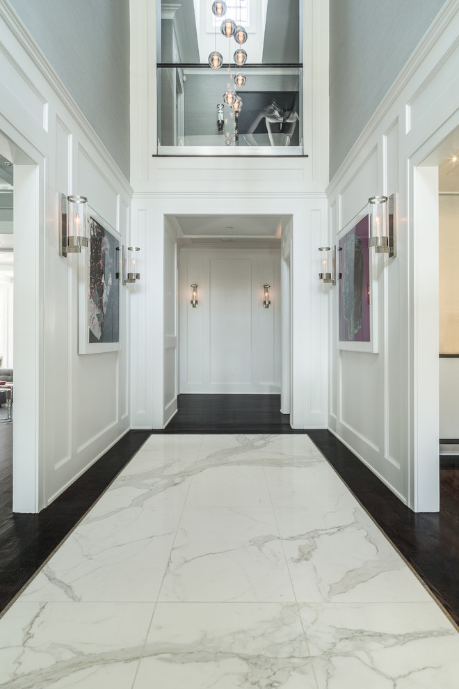 Immagine di un grande corridoio contemporaneo con pareti bianche, pavimento in marmo e pavimento grigio