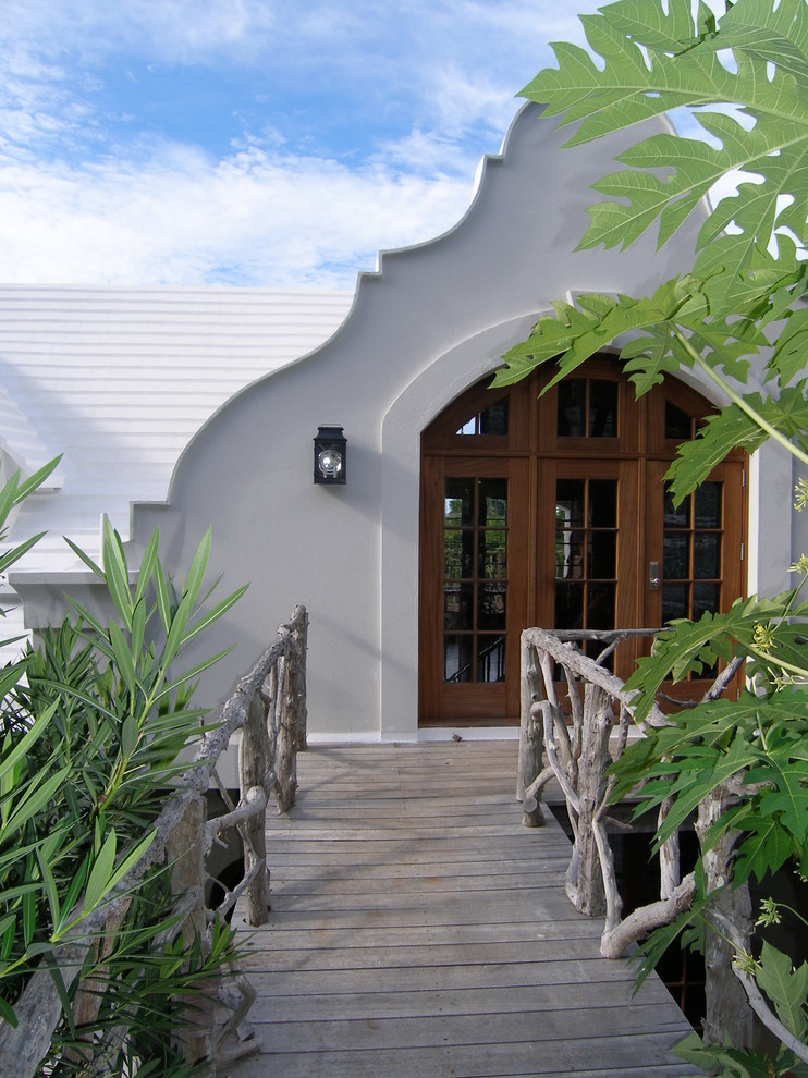 Exempel på en stor exotisk ingång och ytterdörr, med vita väggar, ljust trägolv, en dubbeldörr och mörk trädörr