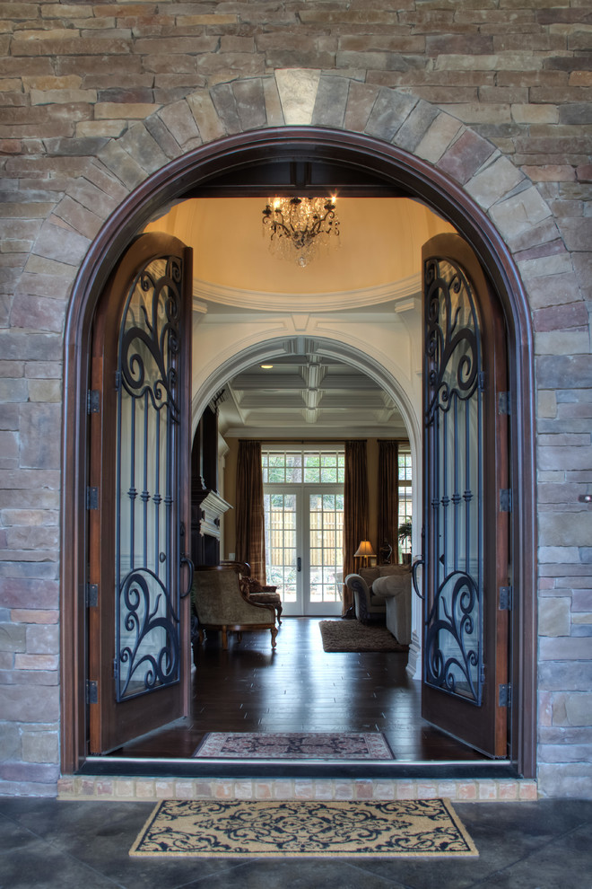 Ejemplo de puerta principal tradicional con puerta doble, puerta de madera oscura, paredes marrones y suelo de madera oscura