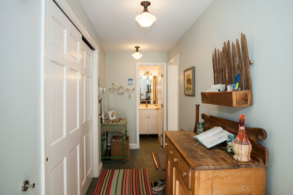 Aménagement d'une petite entrée classique avec un vestiaire, un mur bleu, un sol en ardoise et une porte simple.