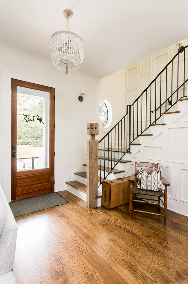 Landhausstil Foyer mit weißer Wandfarbe, braunem Holzboden, Einzeltür, Haustür aus Glas und braunem Boden in Charleston