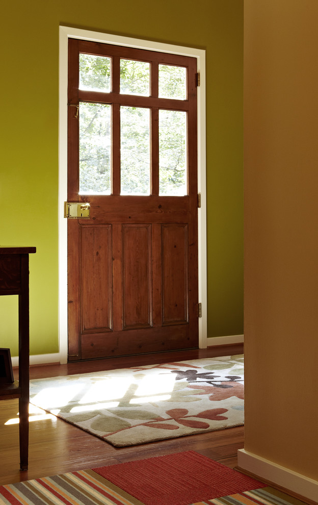 Idee per una porta d'ingresso classica di medie dimensioni con pareti verdi, parquet scuro, una porta singola, una porta in legno bruno e pavimento marrone