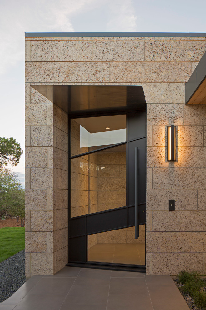 Ispirazione per una porta d'ingresso minimal di medie dimensioni con pareti beige, pavimento in gres porcellanato, una porta singola e una porta in vetro