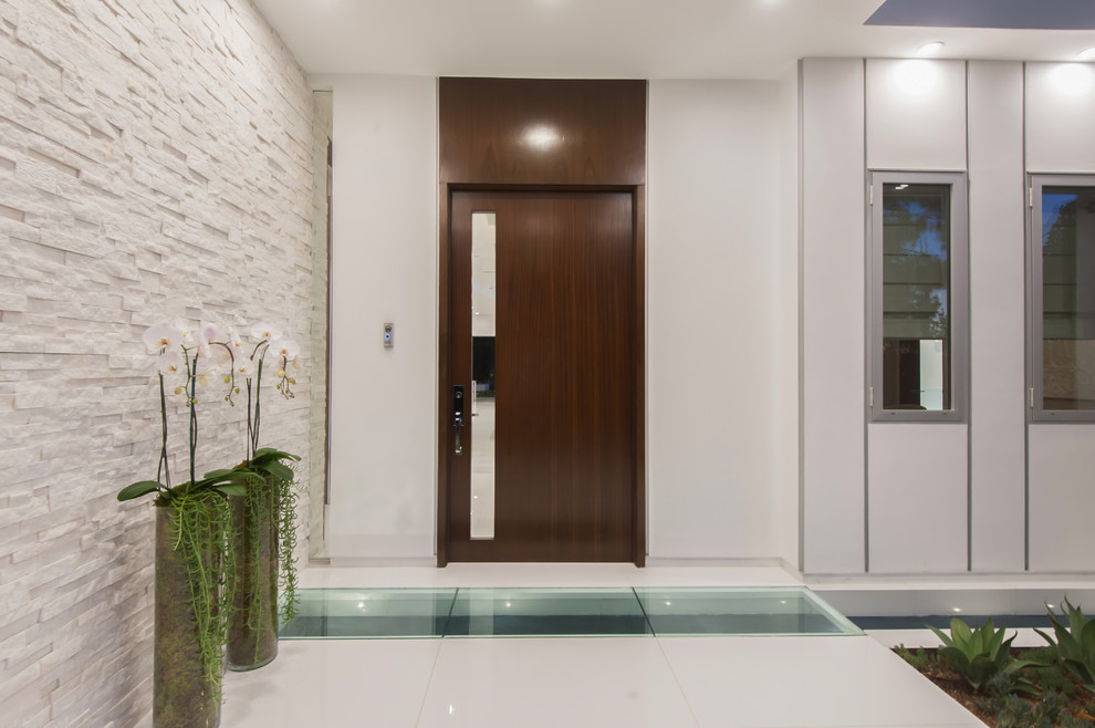 This is an example of a contemporary front door in Los Angeles with a single front door and a dark wood front door.