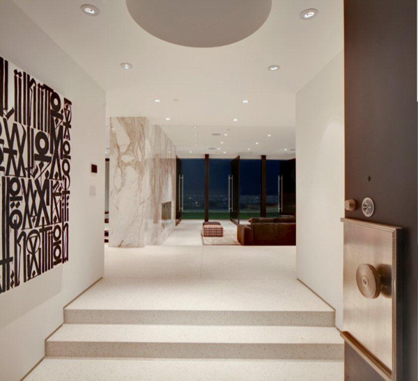 Exemple d'une entrée moderne de taille moyenne avec un couloir, un mur blanc, sol en béton ciré, une porte simple, une porte marron et un sol blanc.