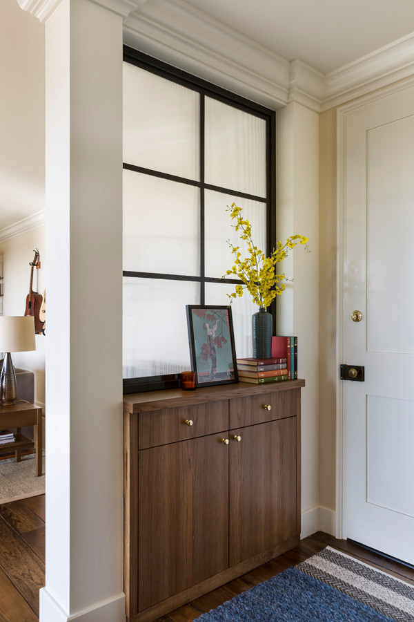 Ejemplo de vestíbulo ecléctico pequeño con suelo de madera en tonos medios, puerta simple, puerta blanca y suelo marrón
