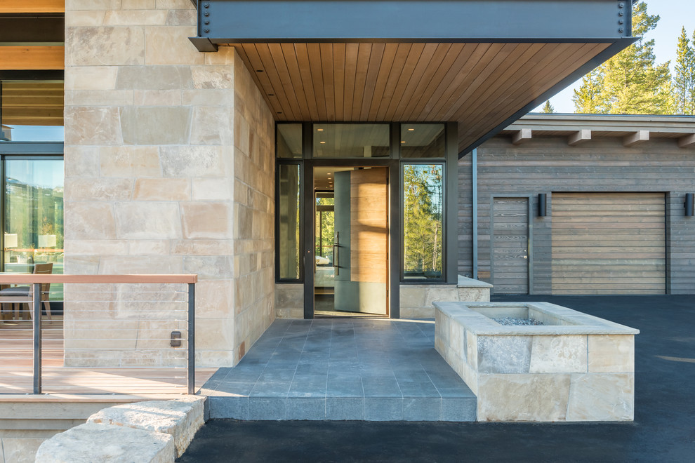 Идея дизайна: входная дверь среднего размера в стиле модернизм с бежевыми стенами, полом из сланца, одностворчатой входной дверью, входной дверью из дерева среднего тона и серым полом