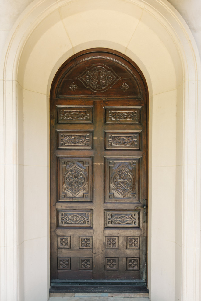 Design ideas for a front door in Los Angeles with beige walls, limestone flooring, a single front door, a dark wood front door and beige floors.