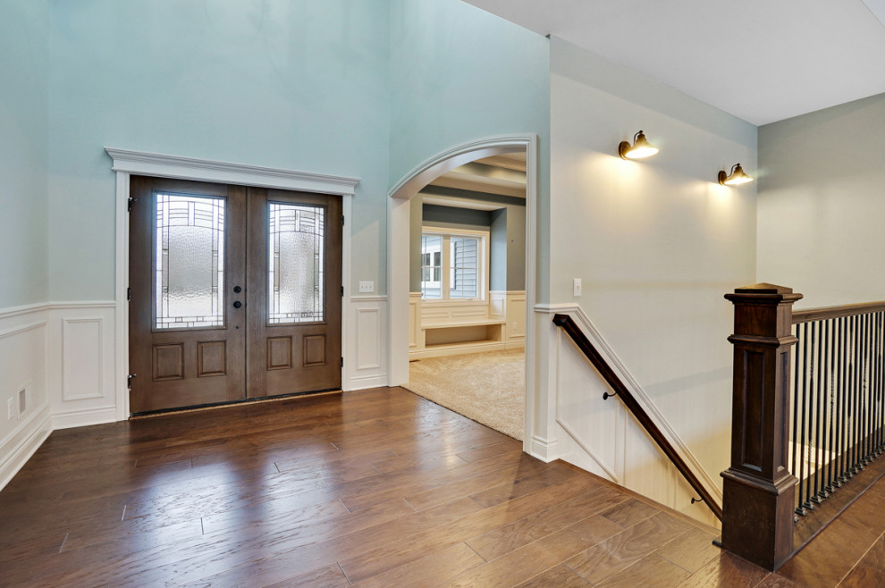Источник вдохновения для домашнего уюта: большое фойе в классическом стиле с синими стенами, паркетным полом среднего тона, двустворчатой входной дверью, входной дверью из темного дерева и коричневым полом