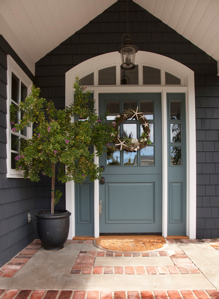 На фото: входная дверь среднего размера в классическом стиле с одностворчатой входной дверью и синей входной дверью